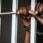 a_mans_hand_cuffed_inside_a_police_cell.jpg