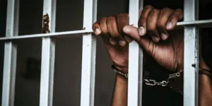 a_mans_hand_cuffed_inside_a_police_cell.jpg